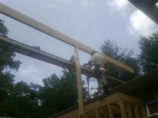 Carpenter setting a ridge beam over a new addition frame — Ice Dam Removal by Roofing Brothers in Frankewing