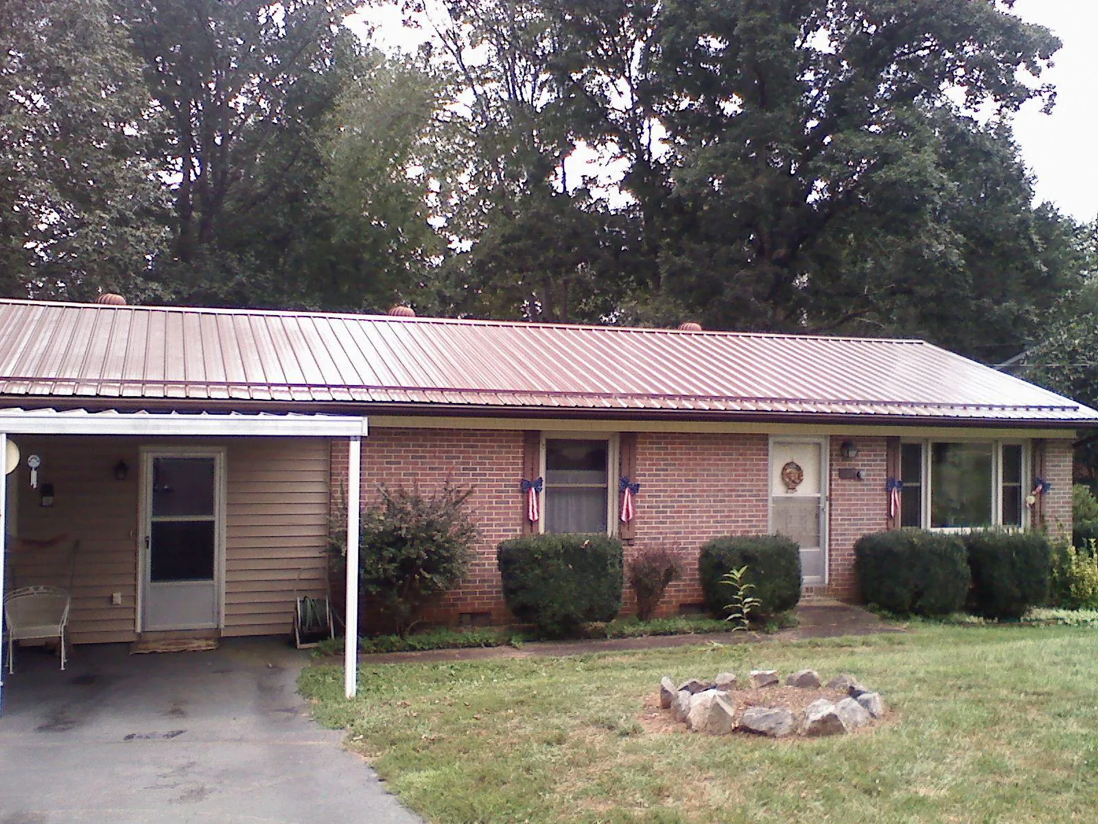 Bronze metal roof and carport on a brick ranch home — Roof Repair work by our crew in Frankewing
